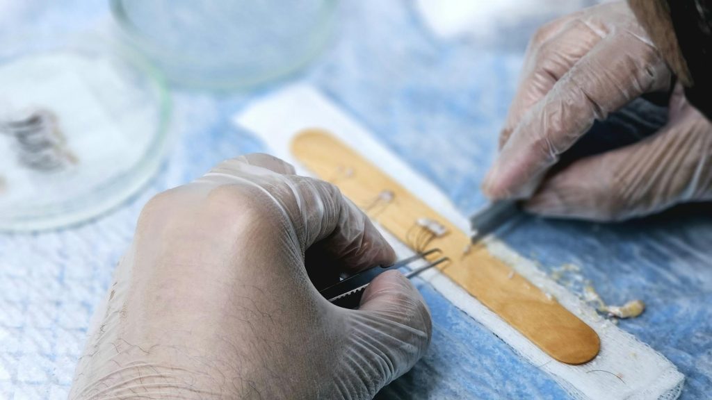 a person in gloves is cutting a piece of bread